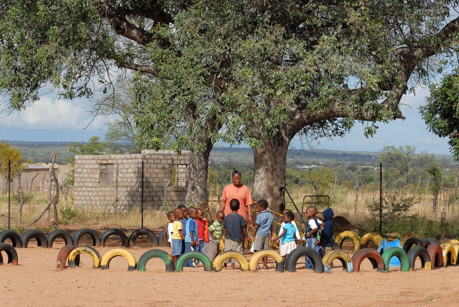 Children gathered under a large tree