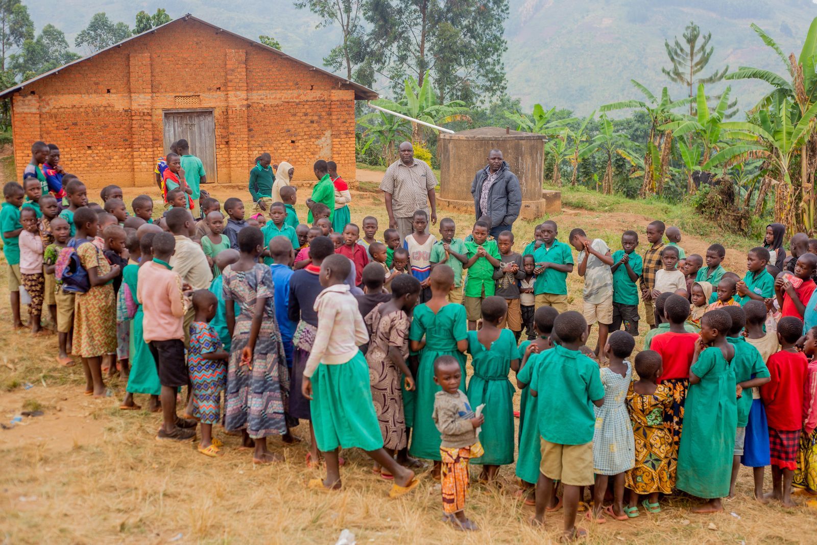Children in green uniforms gathered outside a school